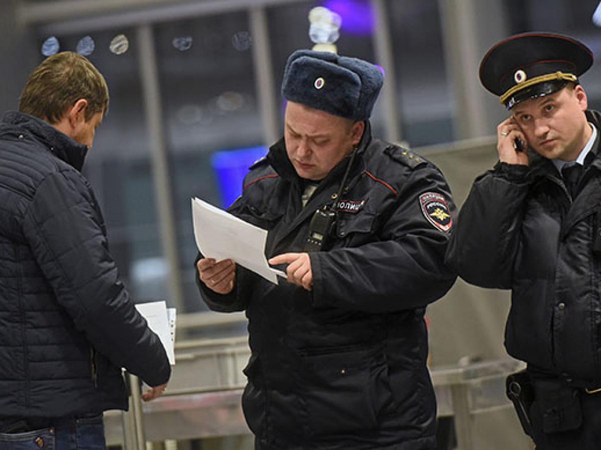 Полицейские проверяют телефоны. Сотрудники правоохранительных органов. Мигранты и полиция. Полиция на вокзале. Полиция проверяет мигрантов.