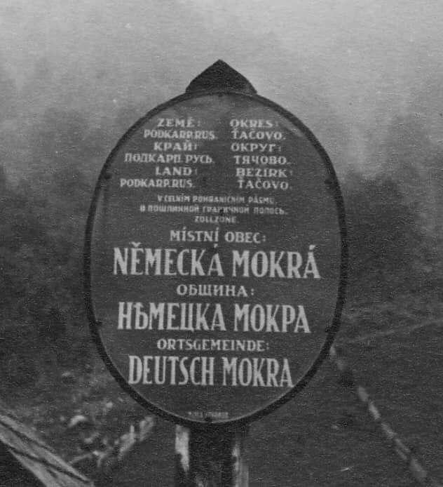 Триязычна табла в подкарпатськōму селї, меживоєнный період. Нїмецка Мокра, округ Тячово.